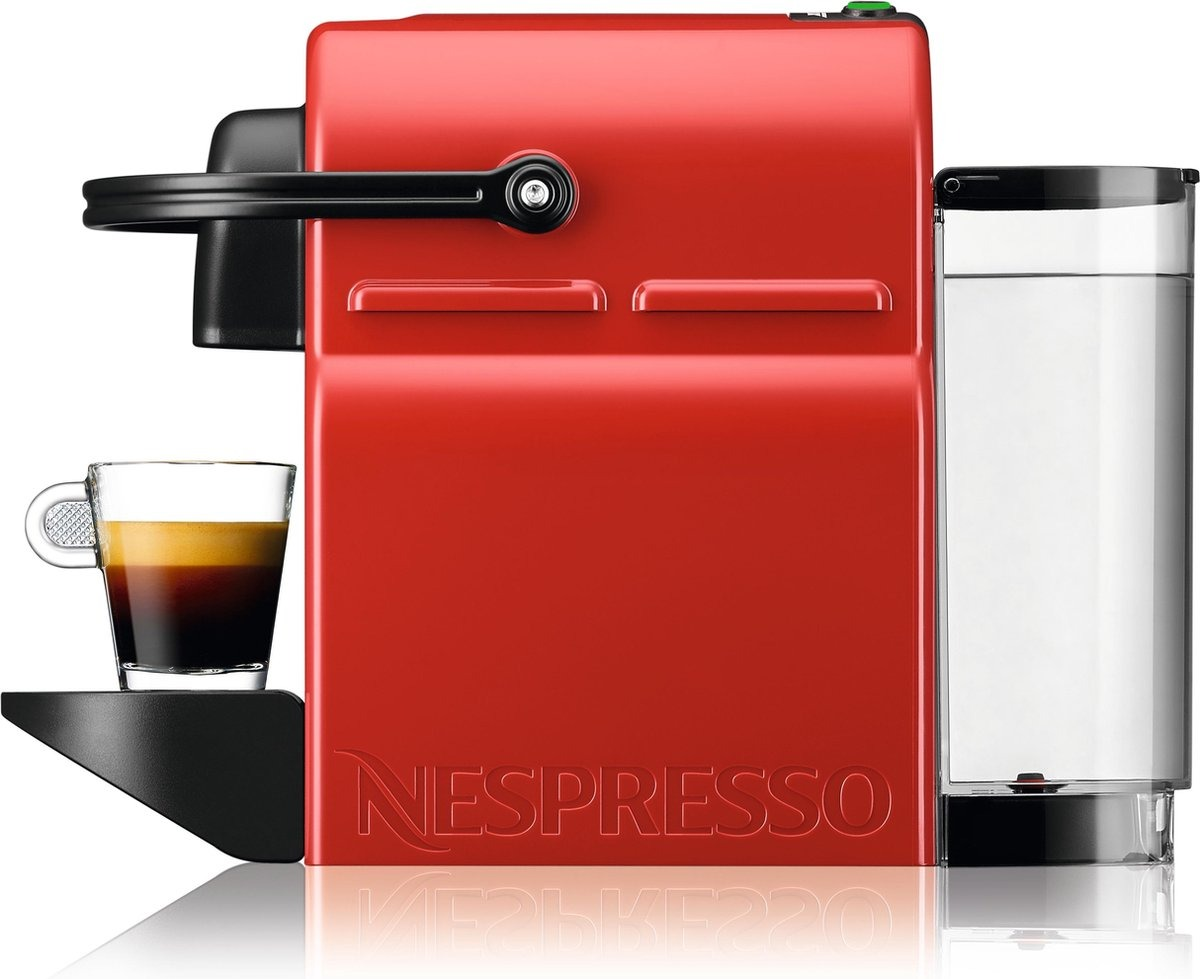 A red Nespresso machine with a glass of espresso. A water reservoir is on the right. The machine is on a white surface.