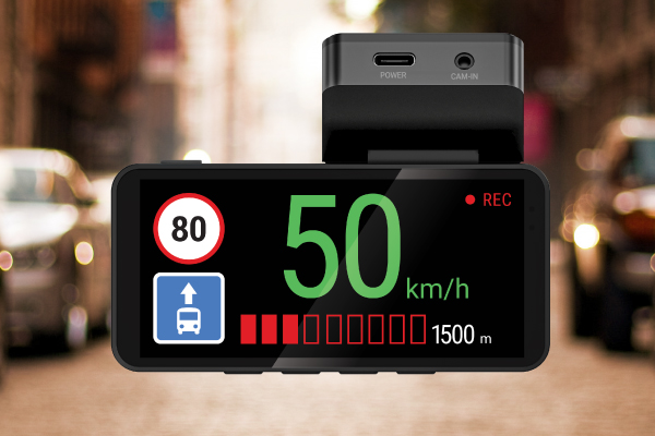 A műszerfal kamera 50 km/h sebességet mutat. 80-as sebességkorlátozó tábla, buszsáv tábla és REC jelző. Homályos utcai háttér.