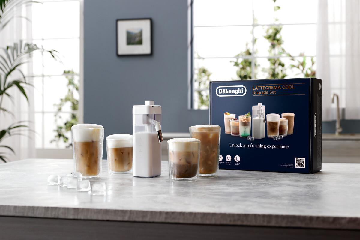 Ein DeLonghi LatteCrema Cool Set mit Eiskaffeegetränken, einem Milchaufschäumer und einer Box auf einer Marmoroberfläche.