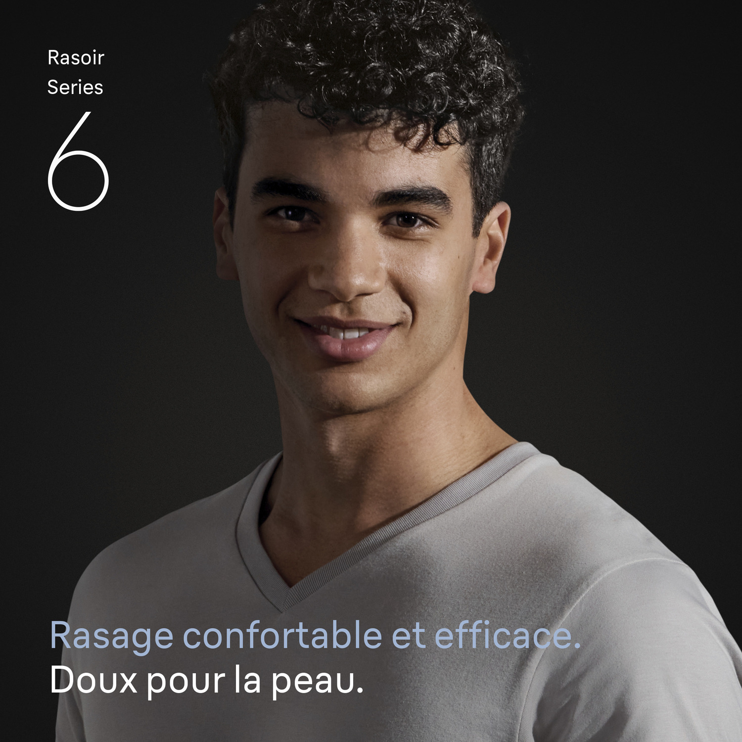 Un homme souriant aux cheveux bouclés foncés porte une chemise grise. Texte : Series 6, Rasage confortable et efficace. Doux pour la peau.