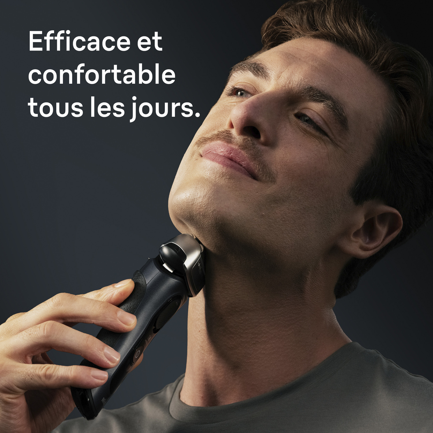 Un homme se rase avec un rasoir électrique noir. Il lève les yeux, souriant légèrement. Fond sombre avec texte blanc : Efficace et confortable.