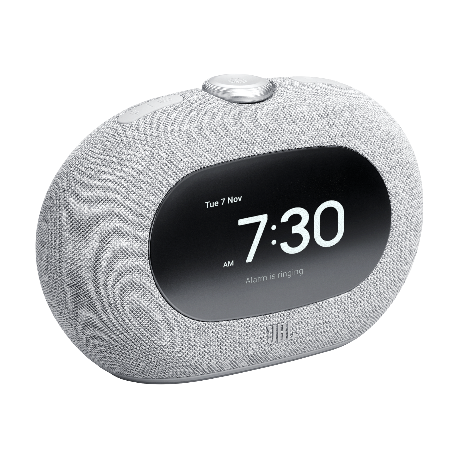 Gri bir JBL çalar saat 7:30 AM ve tarihi gösteriyor. Alarm çalıyor. Kumaş kaplı bir gövdesi ve bir kontrol düğmesi var.