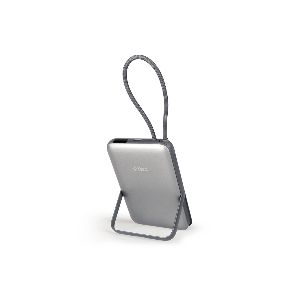 Gri taşıma kayışlı gümüş bir powerbank. Gri bir stand üzerinde duruyor, ttec logosu var ve beyaz zemin üzerine izole edilmiş.