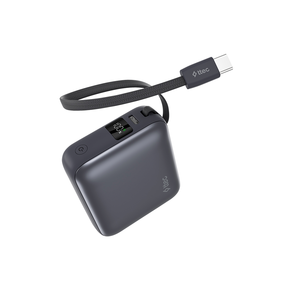 Siyah kayış ve USB-C kablosu ile koyu gri bir güç bankası. Güç bankası, küçük bir ekranda %100 şarj gösteriyor.