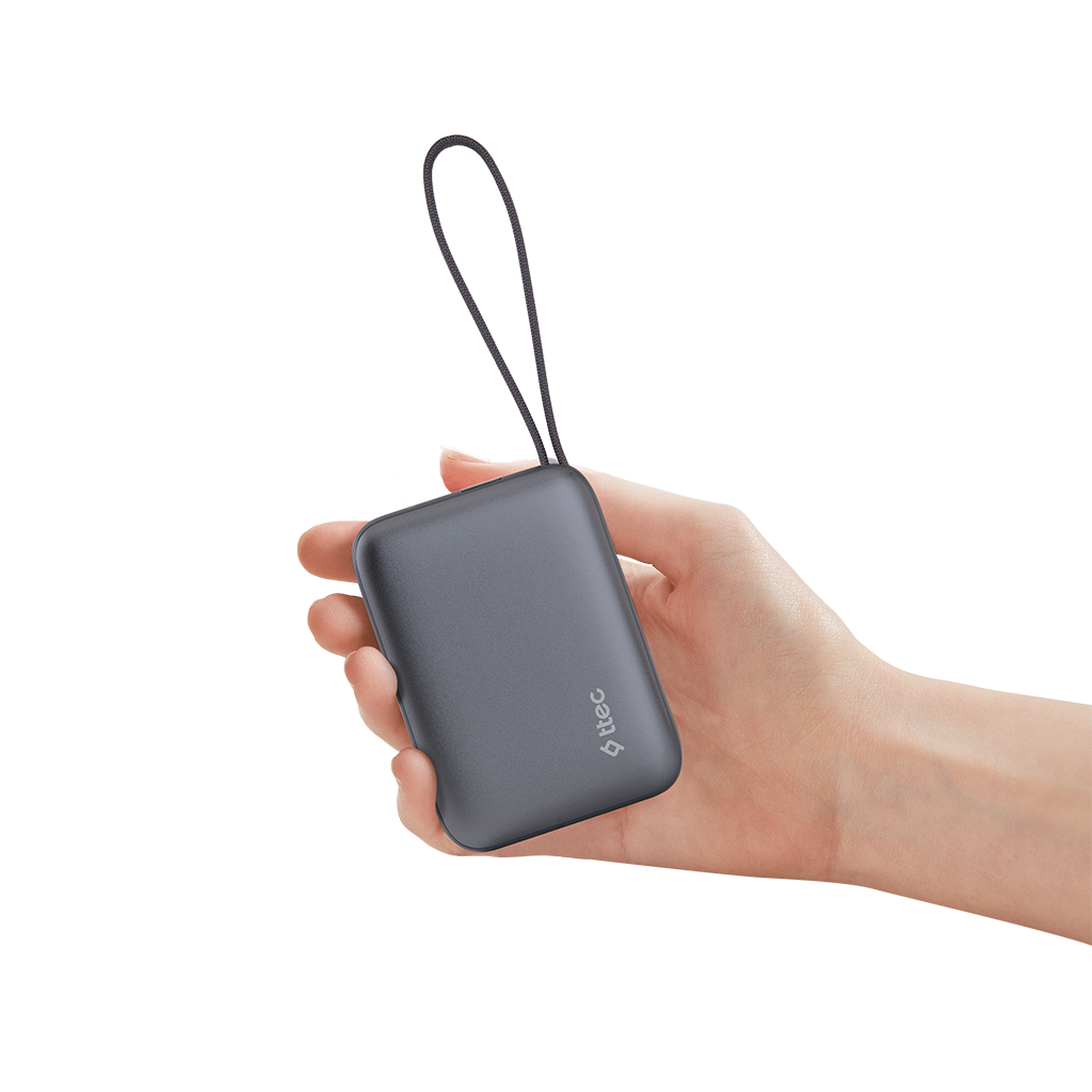 Bir el, halkalı gri dikdörtgen bir powerbank tutuyor. Arka plan, yumuşak gölgelerle beyazdır. Marka logosu görünür.