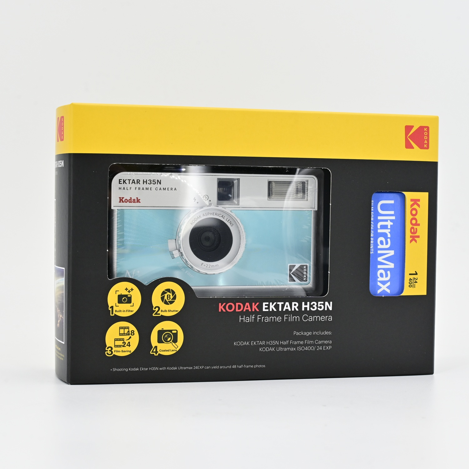 Una confezione della fotocamera Kodak Ektar H35N. Include la fotocamera e la pellicola. La scatola è nera con la parte superiore gialla e la fotocamera blu.