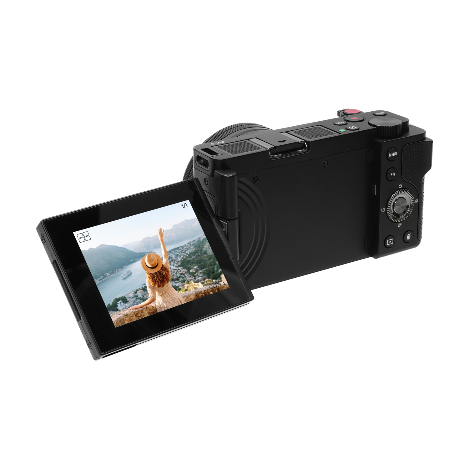 Fotocamera nera che mostra una donna sullo schermo con vista sul mare. La fotocamera ha pulsanti e uno schermo aperto.