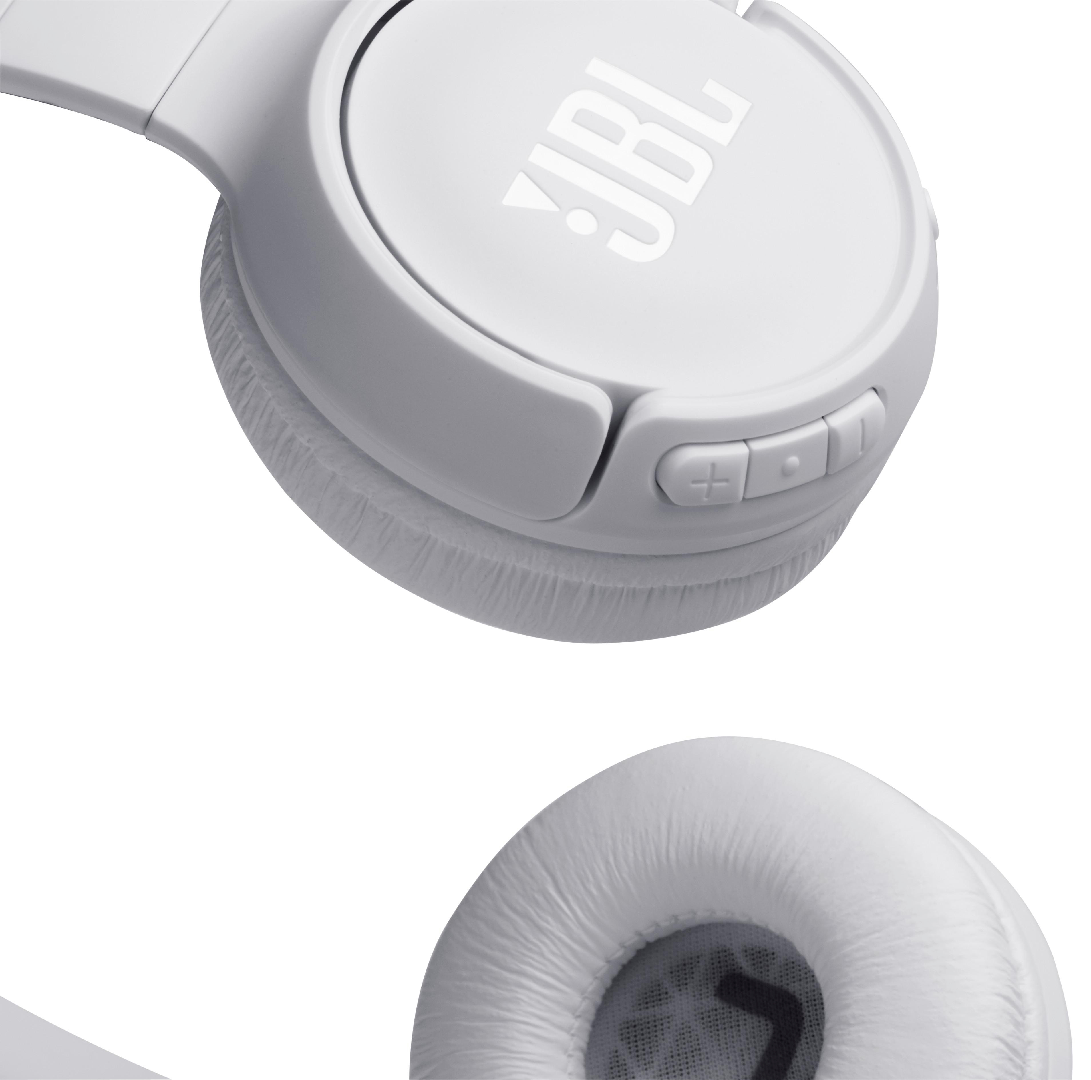 Weiße JBL-Kopfhörer mit sichtbarem Logo. Ein Ohrmuschel ist fokussiert, die andere unscharf.