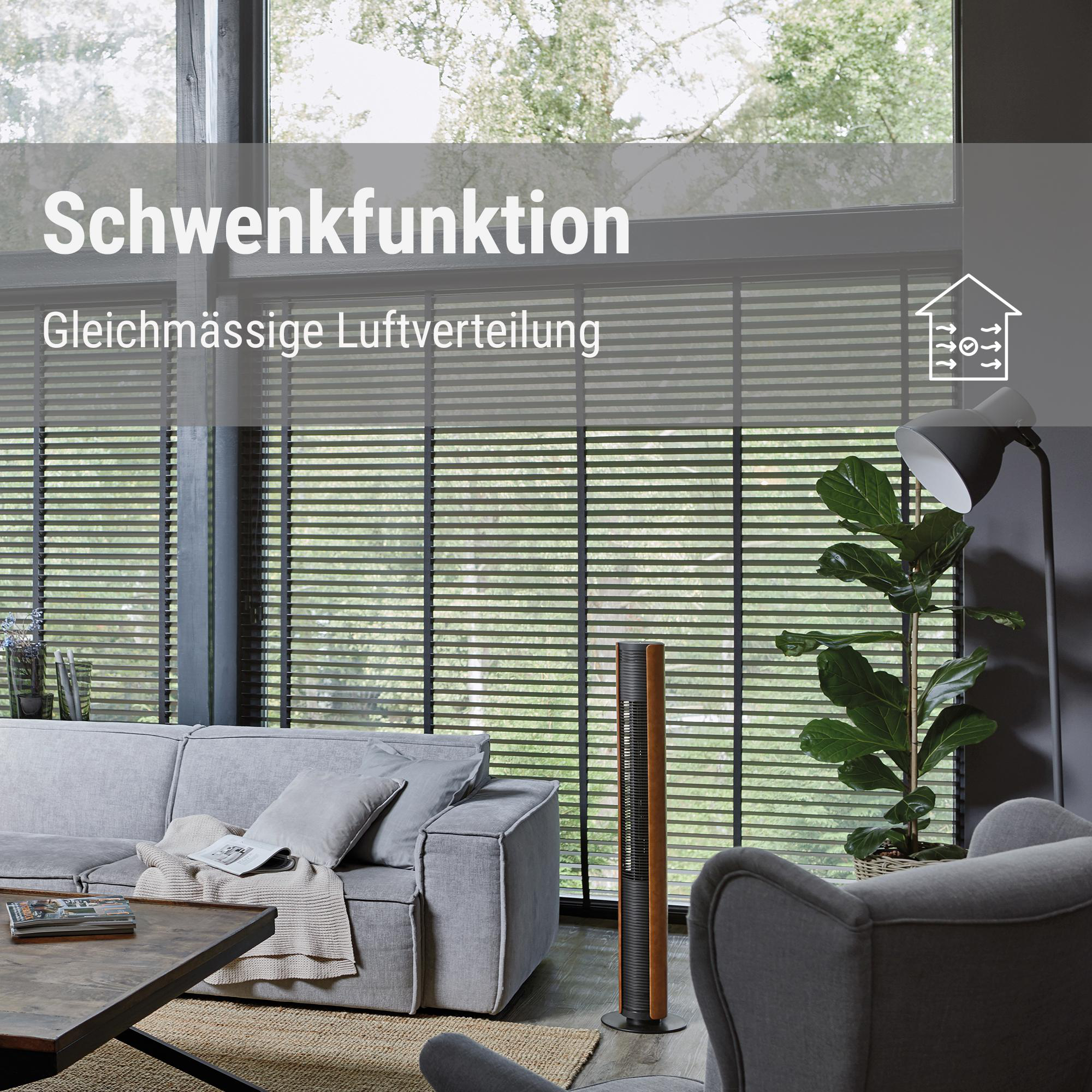 Wohnzimmer mit Ventilator, grauem Sofa, Stuhl und Pflanze. Das Fenster hat Jalousien.