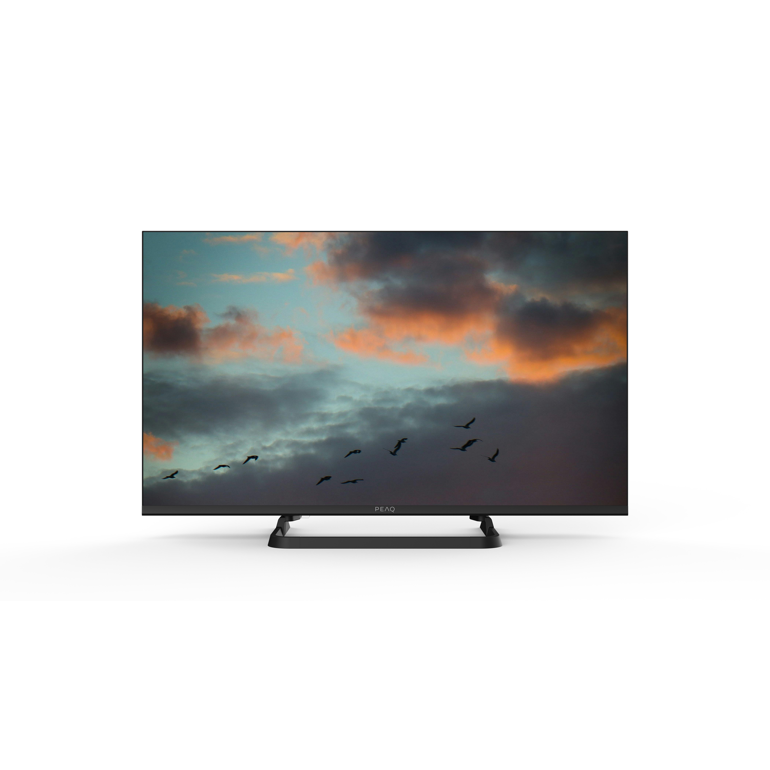 A black PEAQ TV displays a sunset with birds flying across the screen. The TV is on a white background.