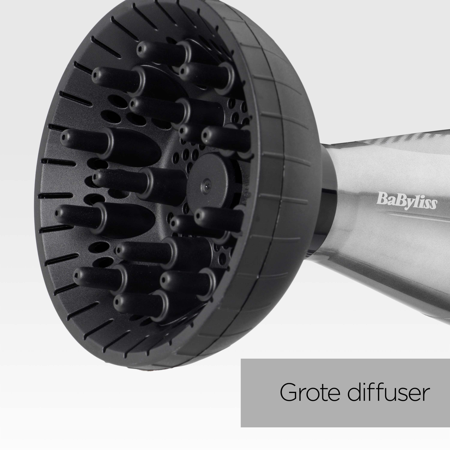 Een zwarte Babyliss haardroger diffuser. Het heeft veel pinnen en gaten. De handgreep is grijs. De tekst "Grote diffuser" staat hieronder.