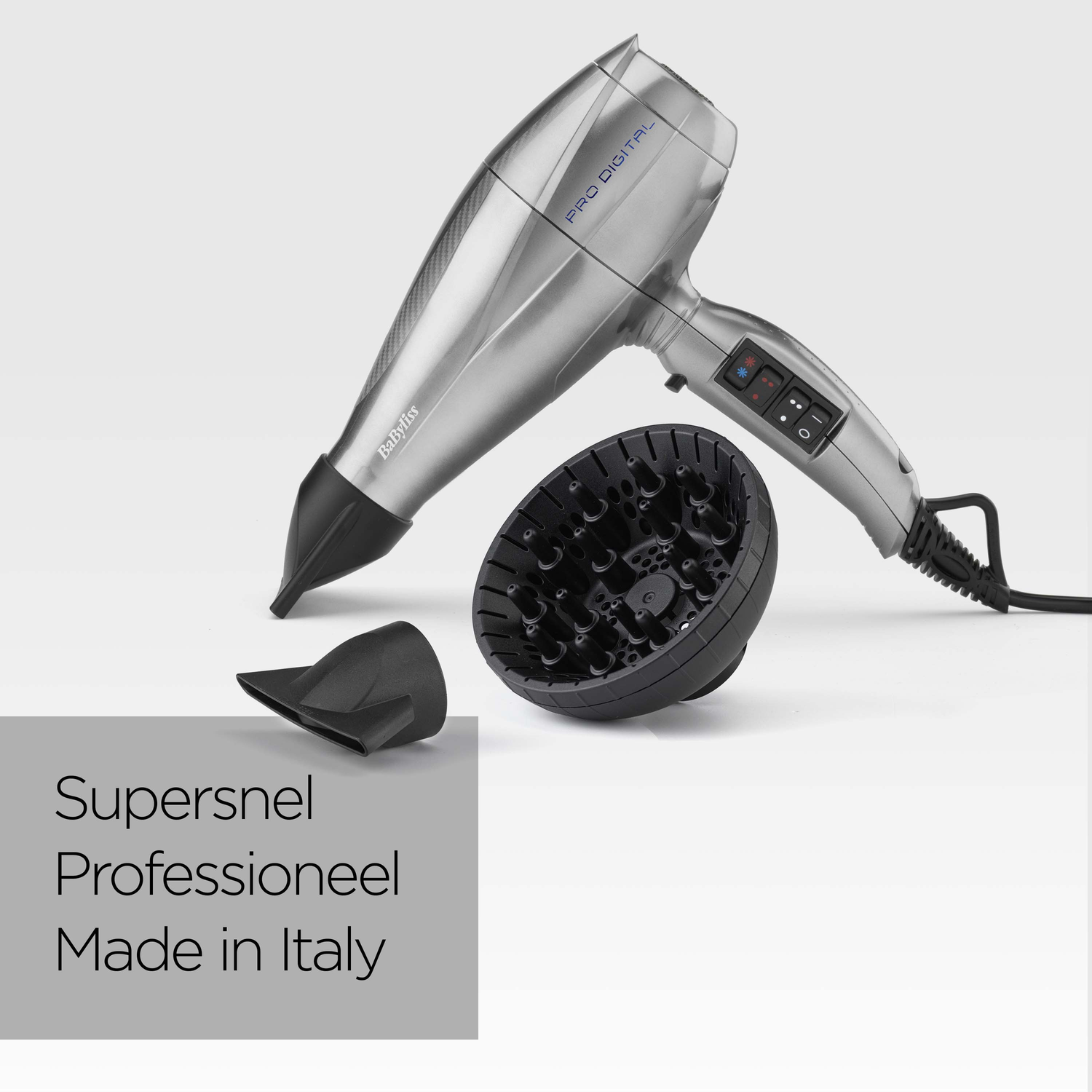 Een zilveren Babyliss Pro Digital haardroger met zwarte opzetstukken. De droger, sproeiers en diffuser staan op een witte achtergrond.