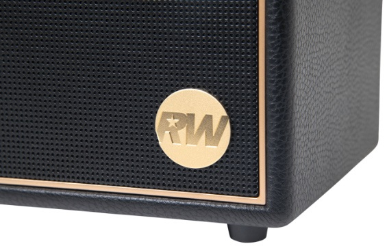 Zbliżenie czarnego głośnika ze złotym logo. Logo zawiera litery RW i gwiazdę. Głośnik ma złote wykończenie.