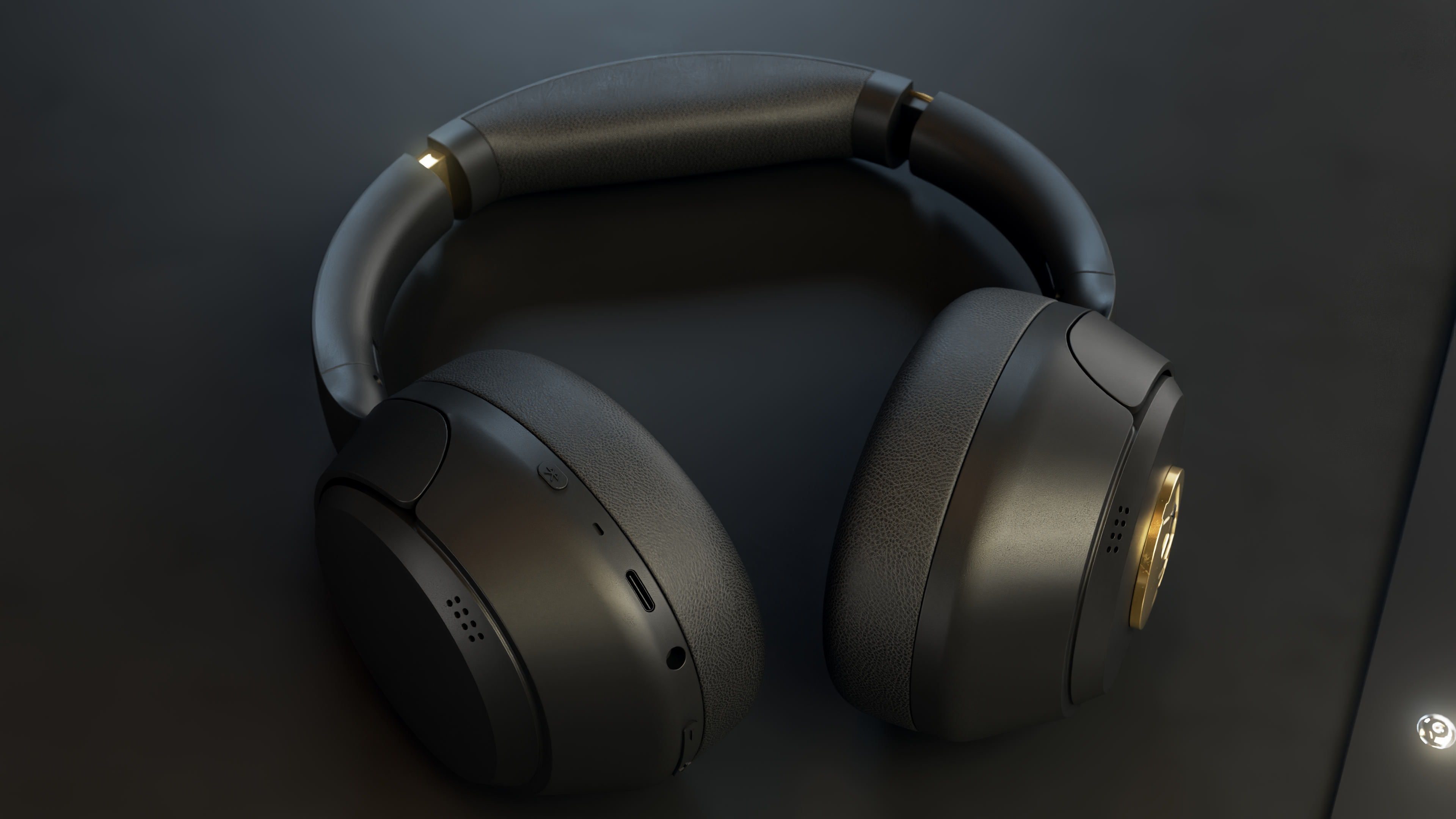 Czarne słuchawki na ciemnej powierzchni. Słuchawki mają złote akcenty i elegancki design. Tło jest ciemne i minimalistyczne.