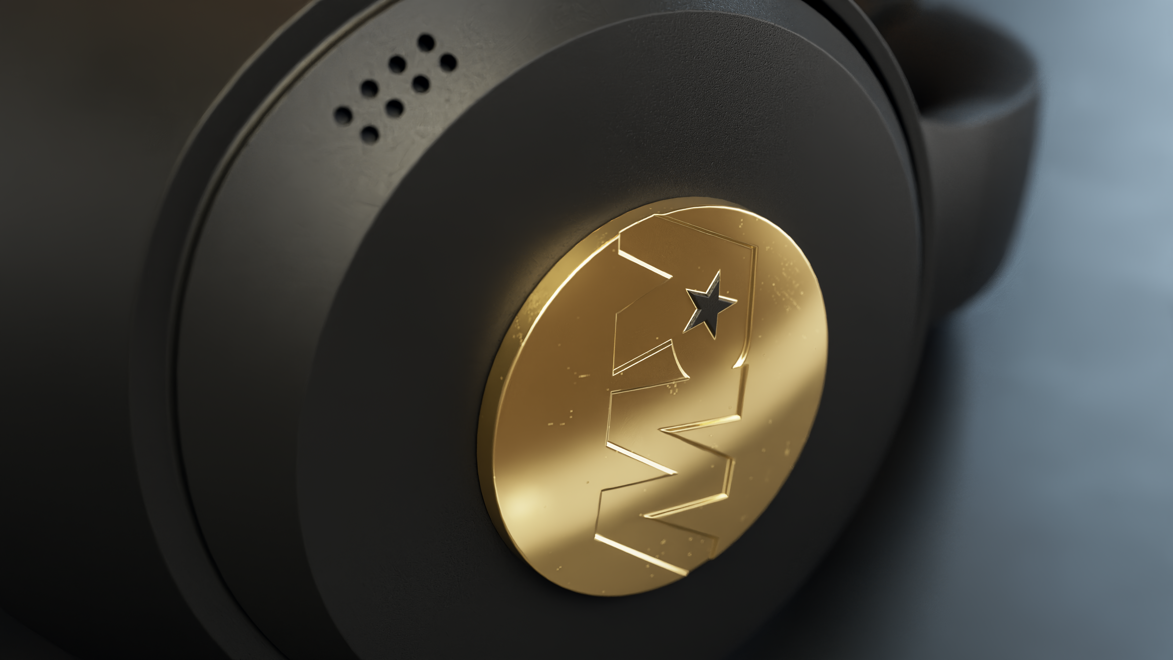 Zbliżenie czarnych słuchawek ze złotym emblematem z gwiazdą. Tło jest ciemnoszare.