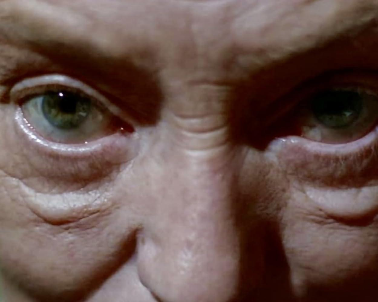 Nahaufnahme eines Gesichts, wobei der Fokus auf den Augen liegt. Grüne Augen mit Falten. Die Haut ist blass mit sichtbaren Poren.