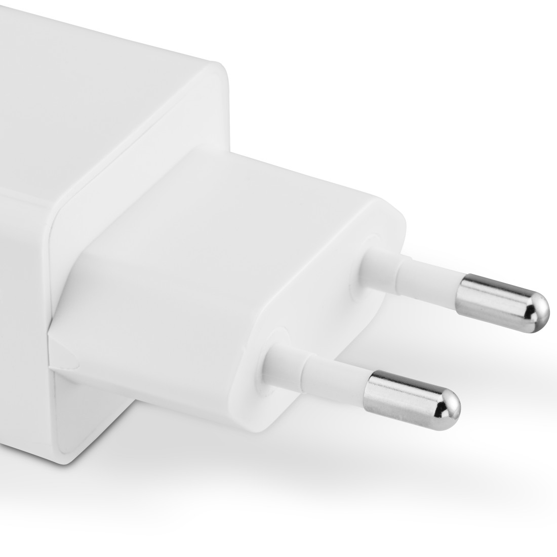 Nahaufnahme eines weißen Netzsteckers mit zwei silbernen Spitzen. Der Stecker liegt auf einer weißen Oberfläche.