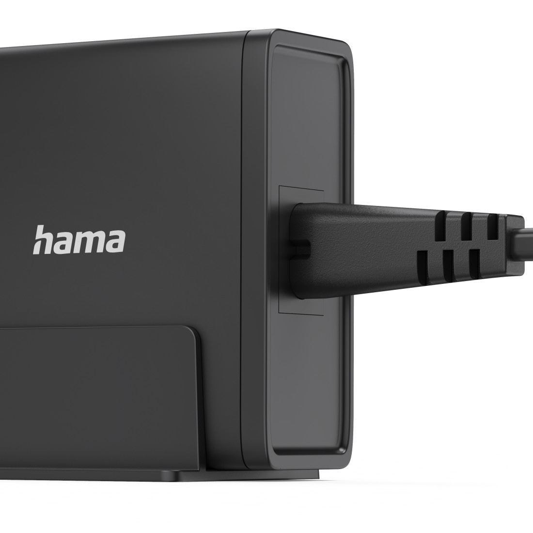 Ein schwarzes Hama-Netzteil mit einem schwarzen Netzkabel. Der Adapter befindet sich auf einer weißen Oberfläche.