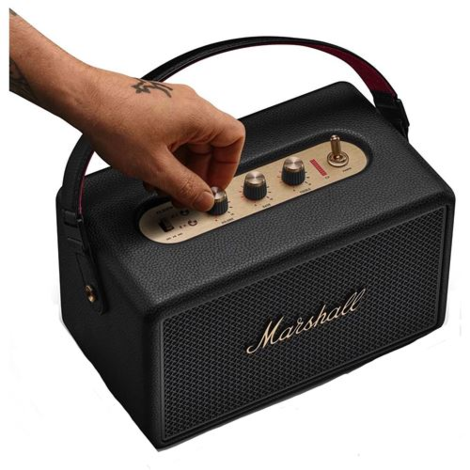 Een zwarte Marshall-luidspreker met een hand die aan een knop draait. De luidspreker heeft gouden accenten en een handvat. Het Marshall-logo is zichtbaar.