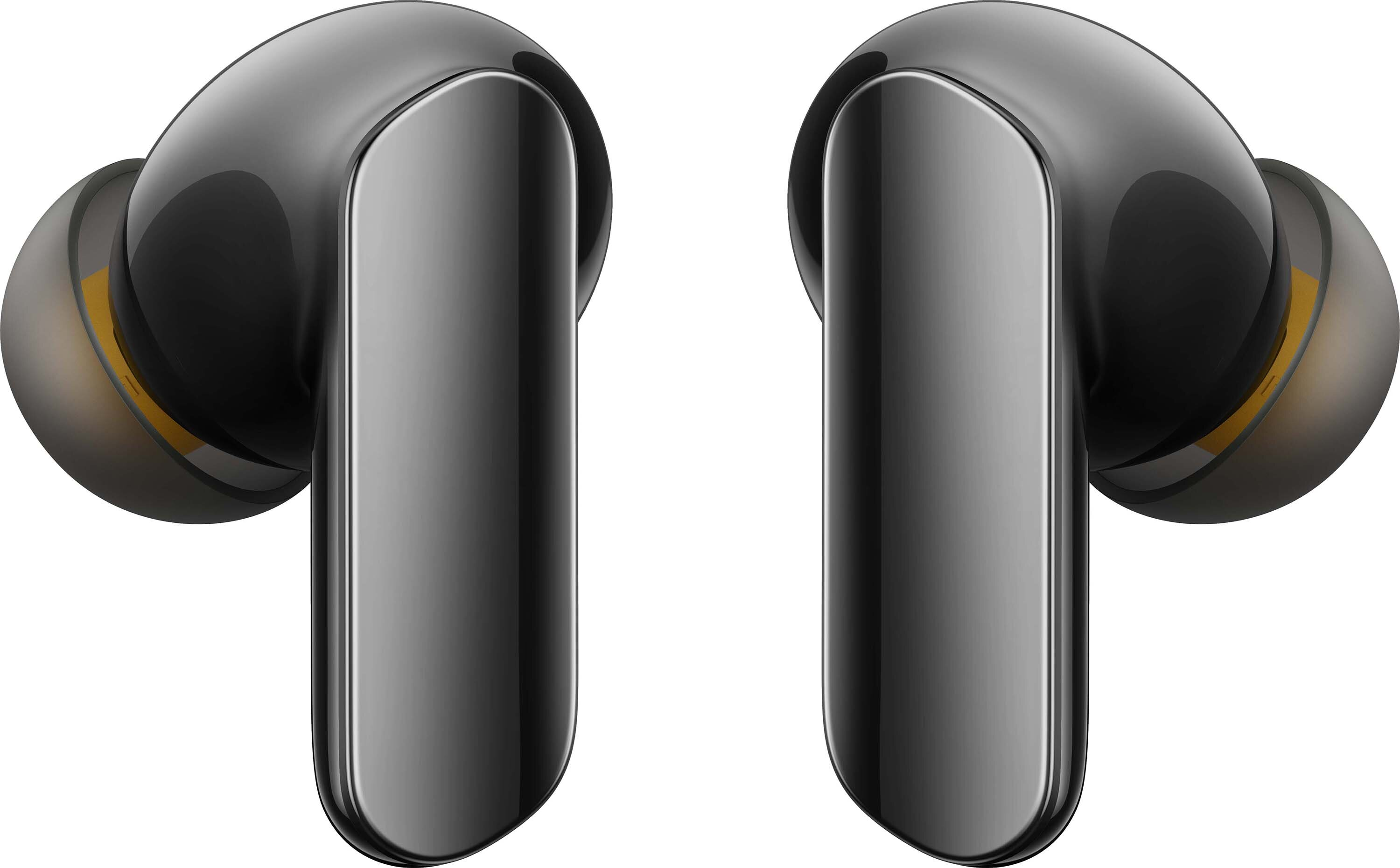 Dwa czarne bezprzewodowe słuchawki. Słuchawki mają błyszczące, metaliczne wykończenie. Końcówki douszne są szare ze żółto-pomarańczowymi detalami.
