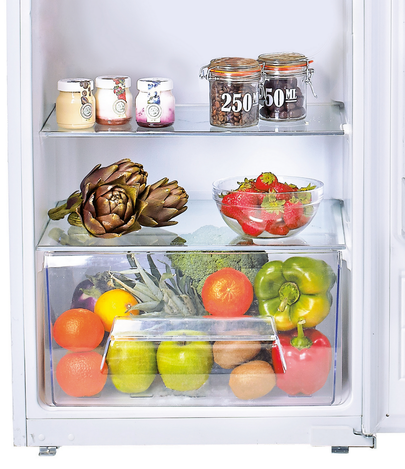 Interior de nevera con varios alimentos: frascos, alcachofas, fresas y verduras. También muestra un cajón con frutas.
