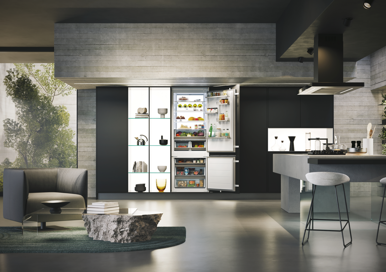 Cocina moderna con nevera abierta, mesa de piedra, sofá gris y armarios negros. La nevera está llena.
