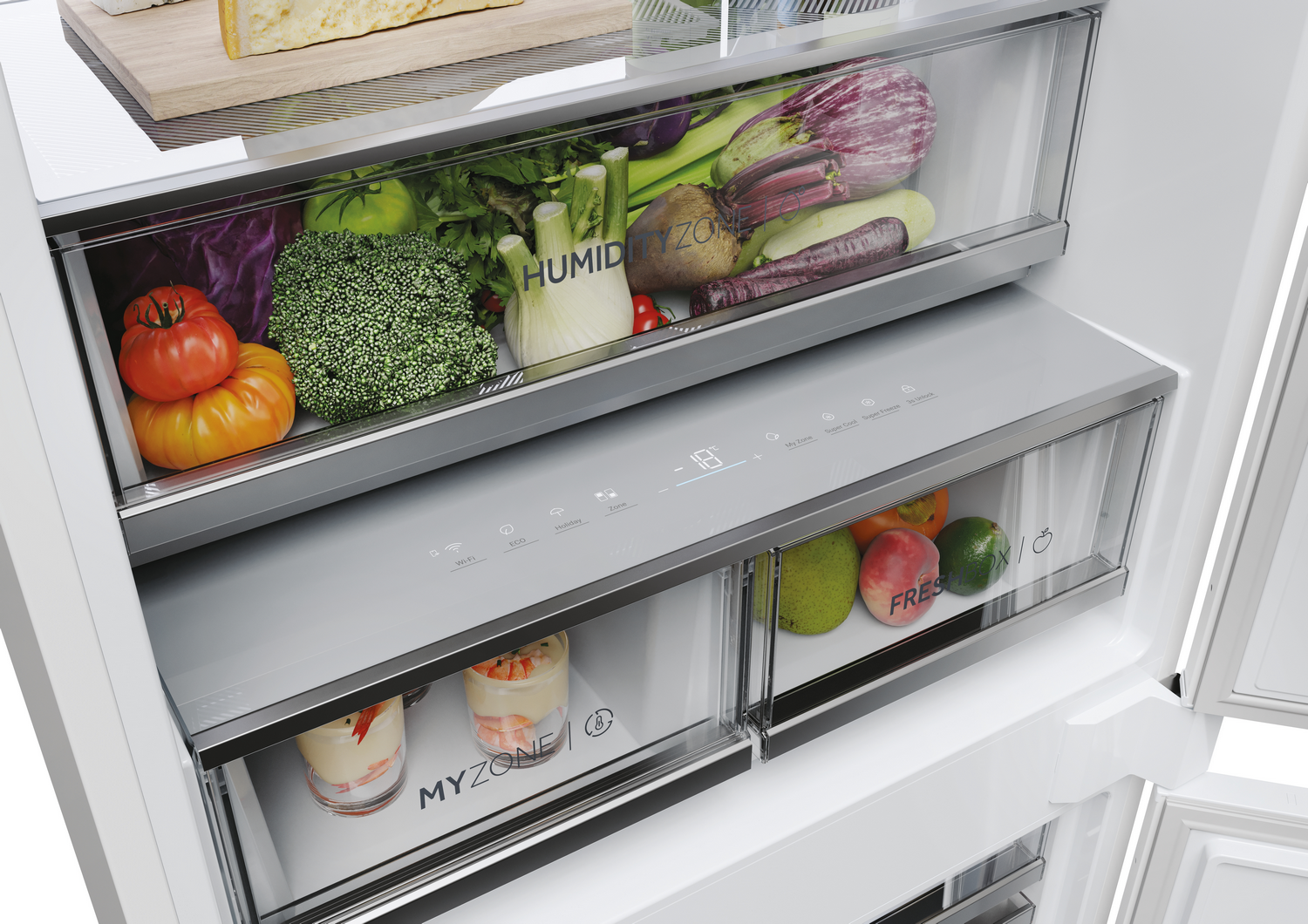 Interior del refrigerador con verduras, frutas y lácteos. Cajones etiquetados HUMID ZONE, MY ZONE y FRESH. Pantalla de temperatura digital.
