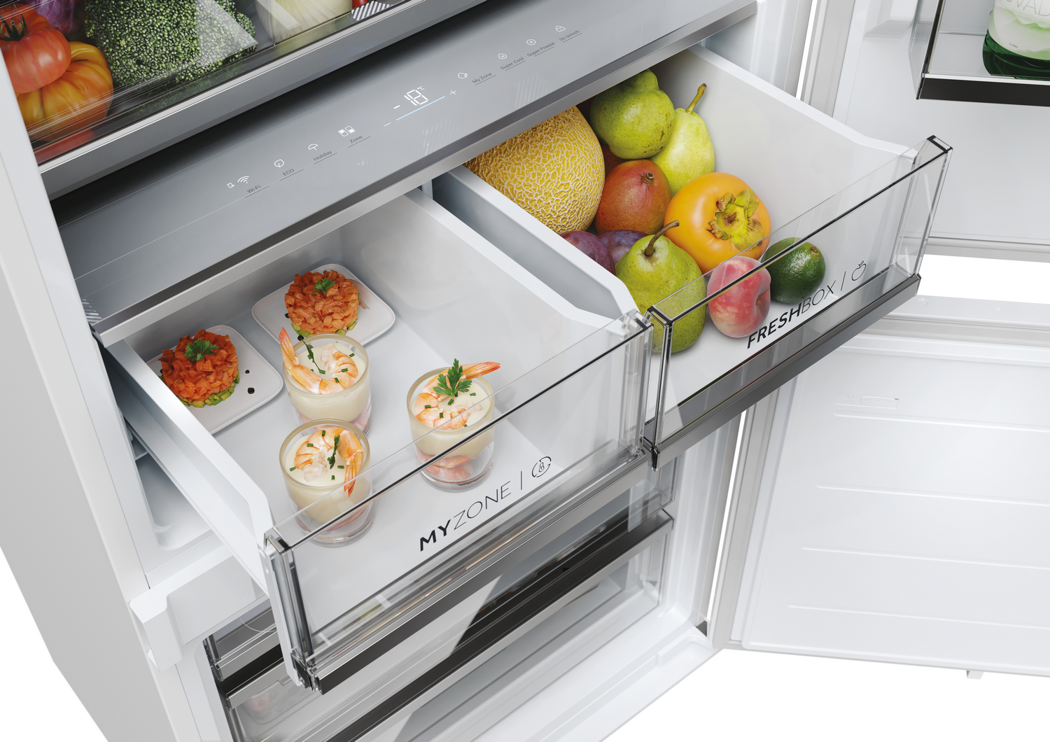 Un cajón de refrigerador con frutas y cócteles de camarones. Incluye peras, melón, caqui. Otro cajón tiene aperitivos de camarones preparados.