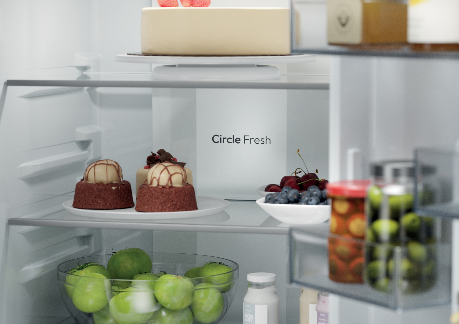 Dentro de la nevera: se ven pastel, pasteles, bayas y tarros. 'Circle Fresh' está escrito en la pared trasera.