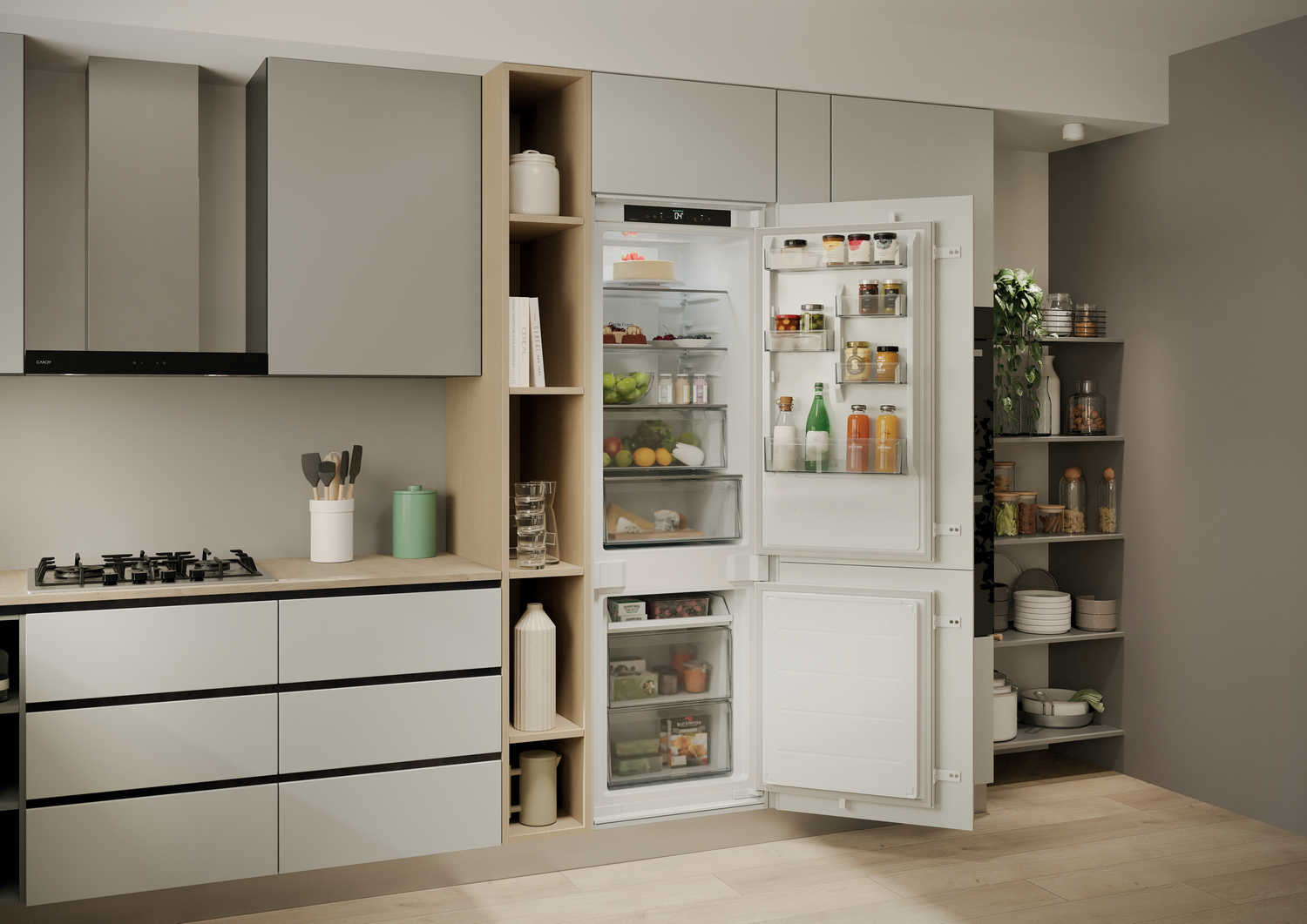 Interior de cocina con refrigerador abierto lleno de comida. Se ven gabinetes grises, una estufa y estantes de despensa con frascos.