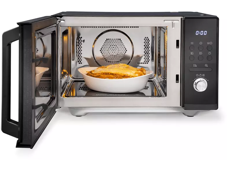 Mikrofalówka z otwartymi drzwiami. W środku naczynie z lazanią. Mikrofalówka ma czarny panel sterowania.