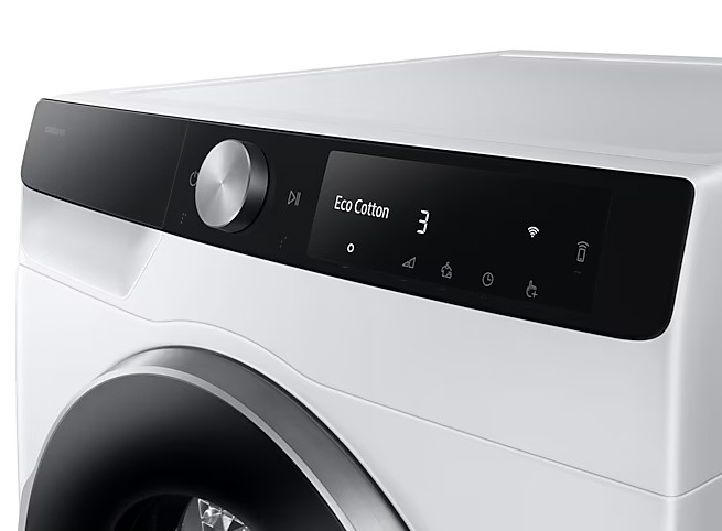 Panel sterowania białej pralki. Ma czarny wyświetlacz z napisem Eco Cotton, cyfrą 3 i różnymi ikonami. Srebrne pokrętło.