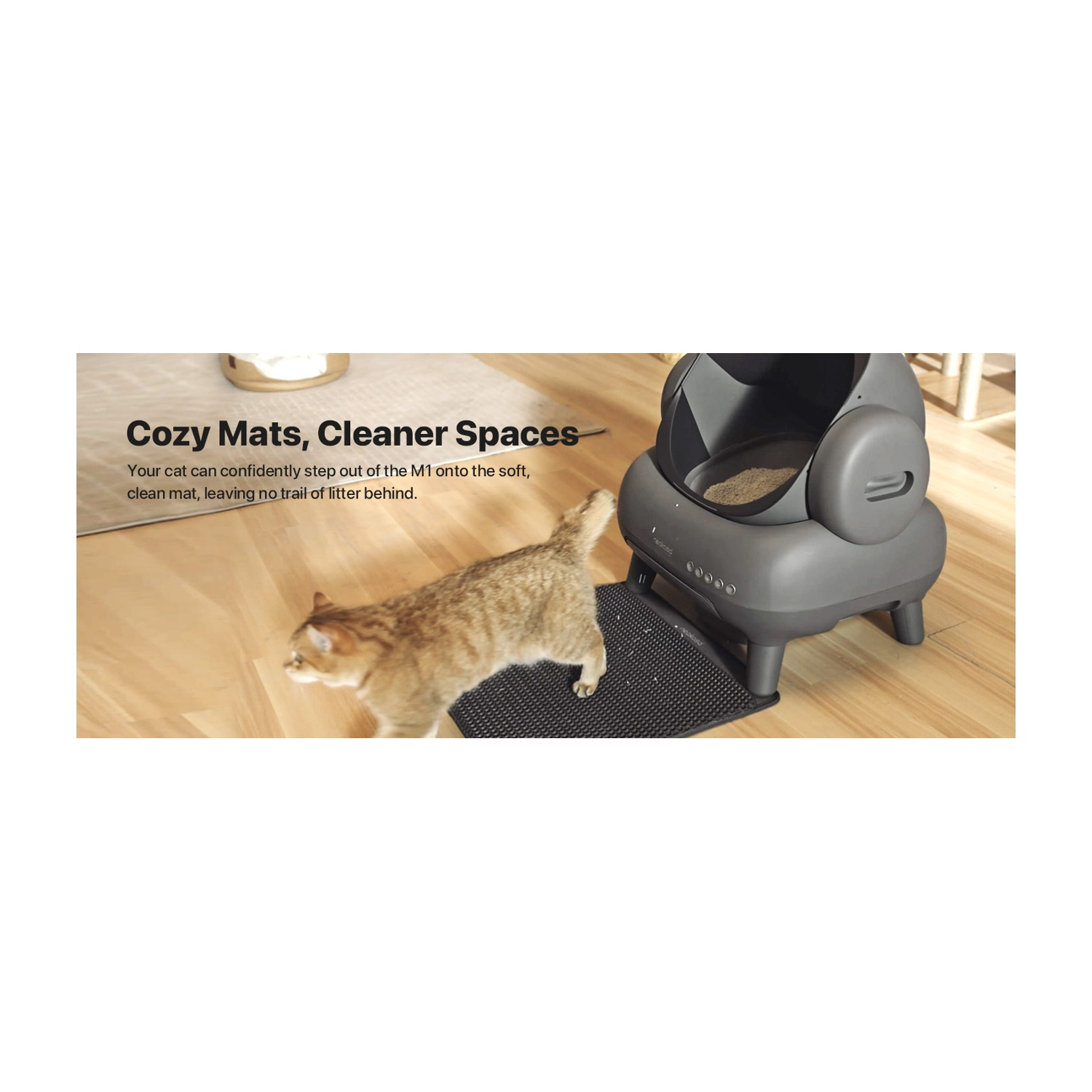 Un gatto cammina verso una lettiera grigia autopulente su un tappetino. Il testo recita 'Cozy Mats, Cleaner Spaces'.