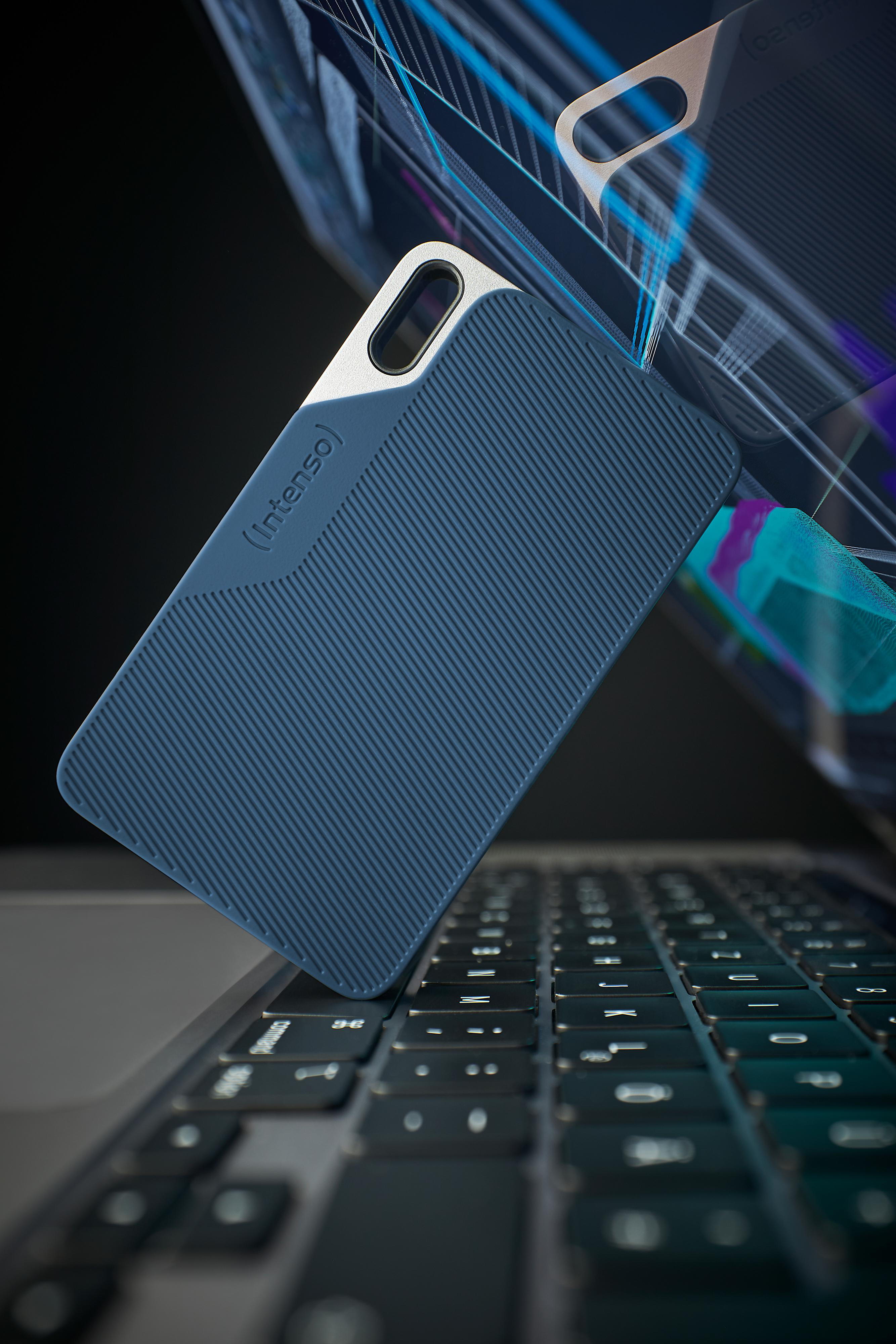 Una custodia blu con il logo Intenso fluttua sopra una tastiera di un laptop. Sullo sfondo è visibile uno schermo.