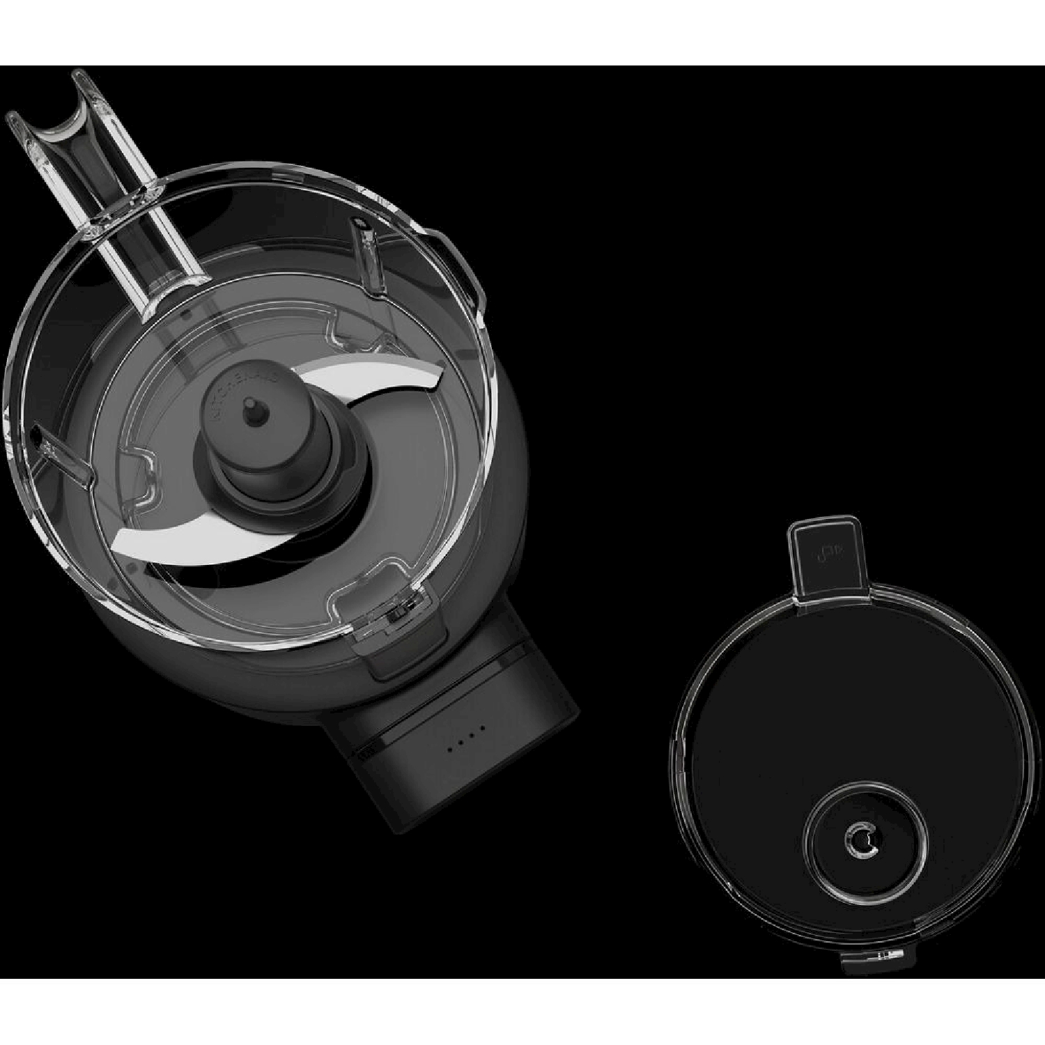 Un robot da cucina nero con coperchio trasparente e lama è su una superficie nera. È visibile anche un coperchio.