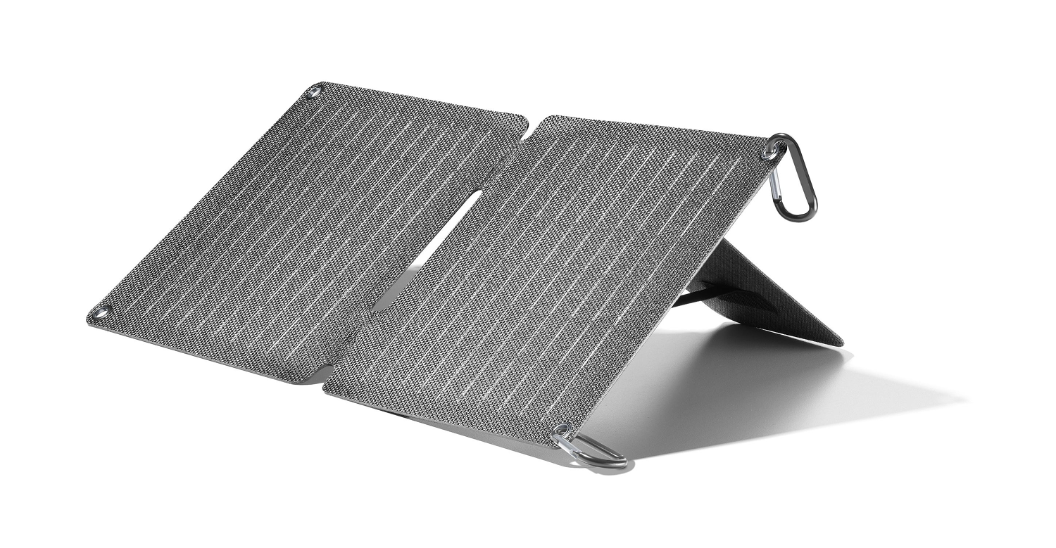 Un panel solar gris plegable se muestra abierto sobre un fondo blanco. Tiene una textura similar a una malla y anillos metálicos.