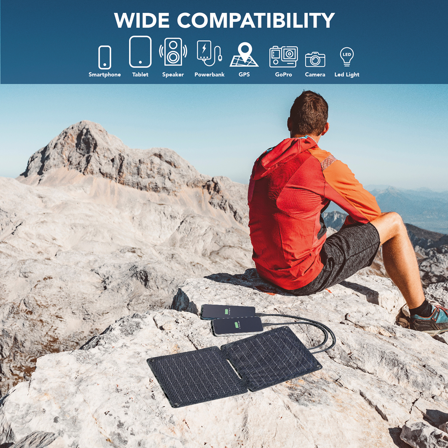 Una persona con una chaqueta roja está sentada en una montaña, cargando dispositivos con un panel solar. Iconos de amplia compatibilidad arriba.
