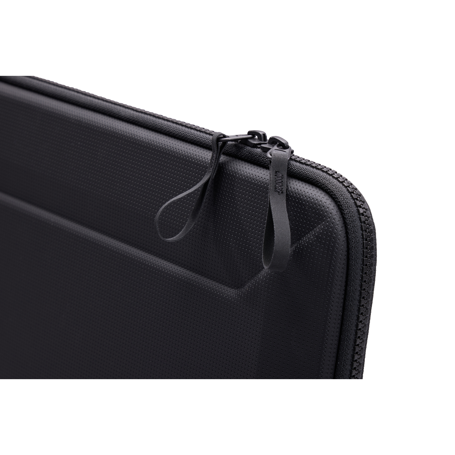 Close-up of a black laptop case with a zipper. The case has a textured surface. A black strap is attached to the zipper.