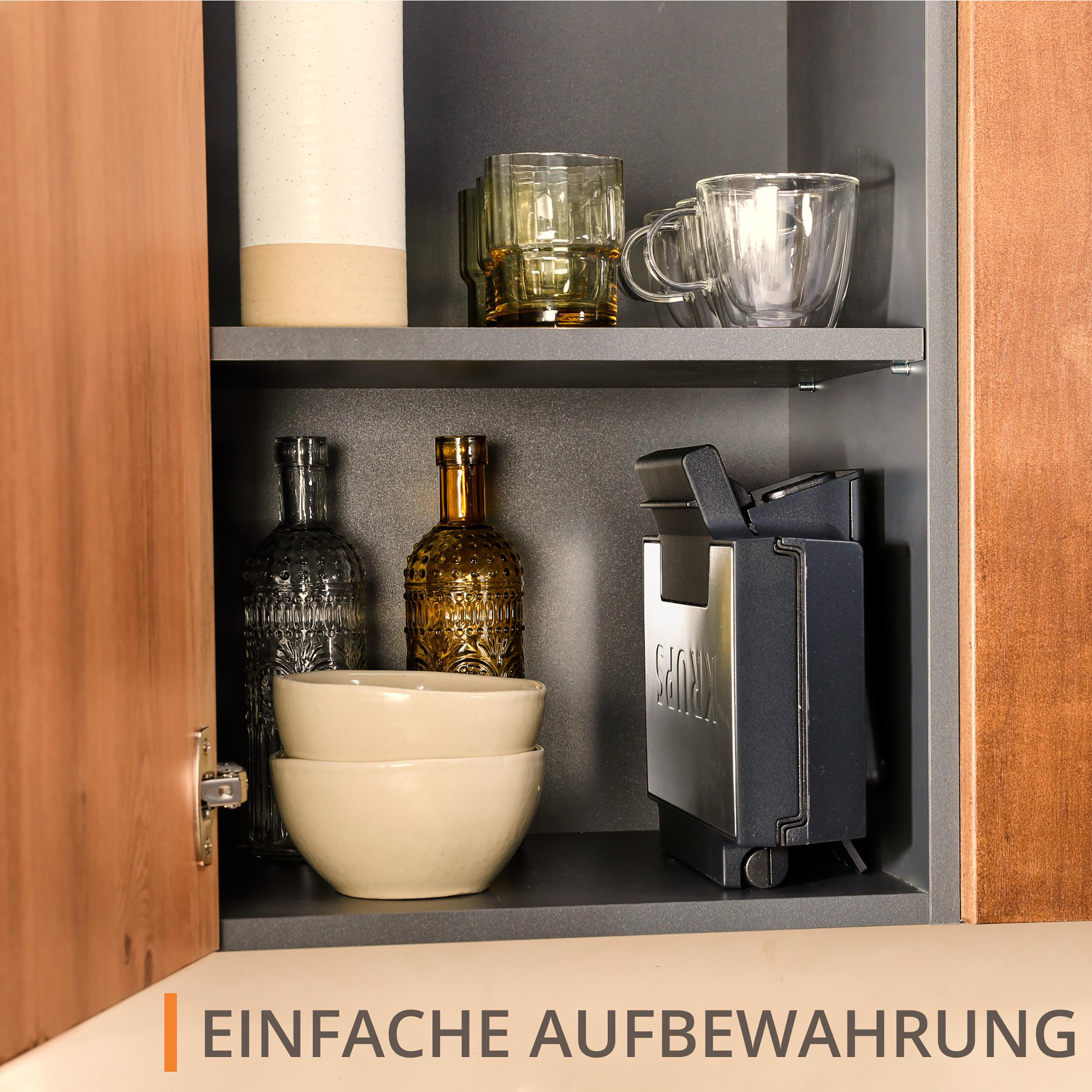 Ein offener Küchenschrank mit Gläsern, Schalen und einer Kaffeemaschine. Der Schrank hat Holz- und dunkelgraue Oberflächen.