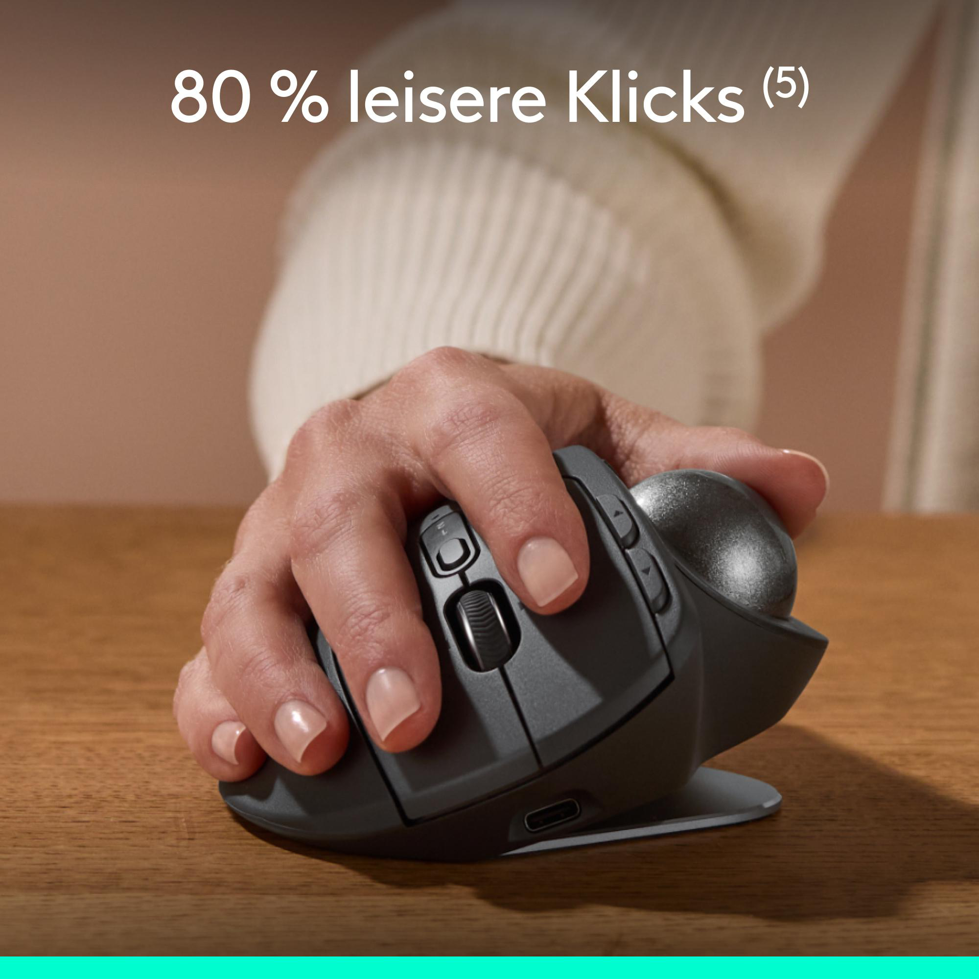 Hand hält eine dunkelgraue Trackball-Maus auf Holz. Weißer Text: '80 % leisere Klicks'.