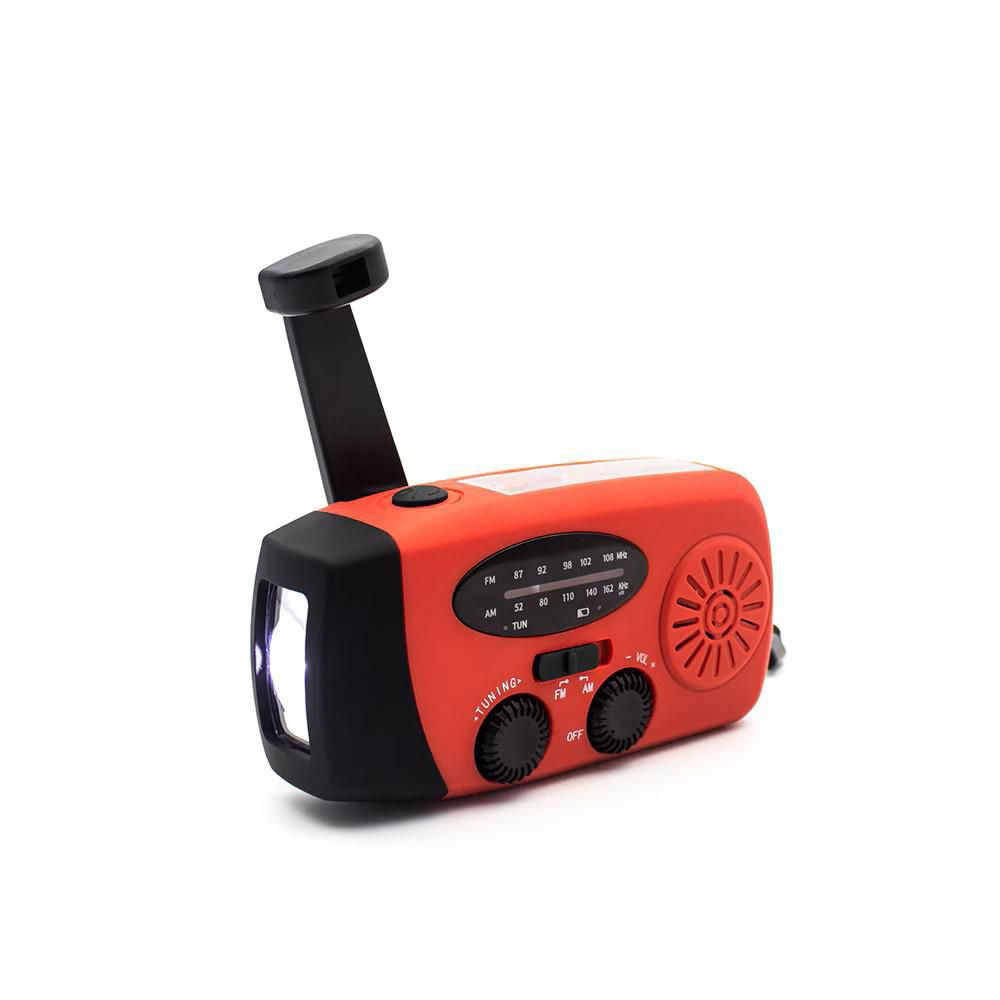 Ein orangefarbenes und schwarzes Handkurbelradio mit einer Taschenlampe. Das Radio hat eine Kurbel und einen Lautsprecher. Es befindet sich auf weißem Hintergrund.