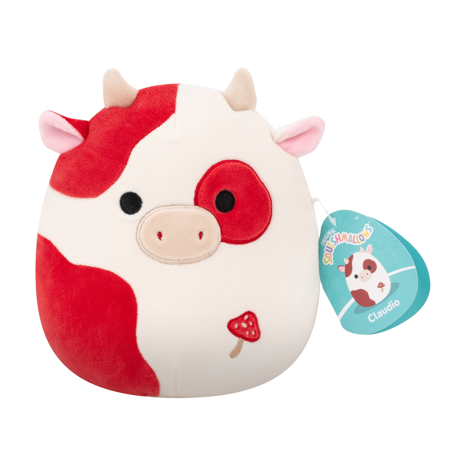 Un peluche a forma di mucca con macchie rosse e un fungo. Ha un'etichetta con scritto Claudio. Il giocattolo è su sfondo bianco.