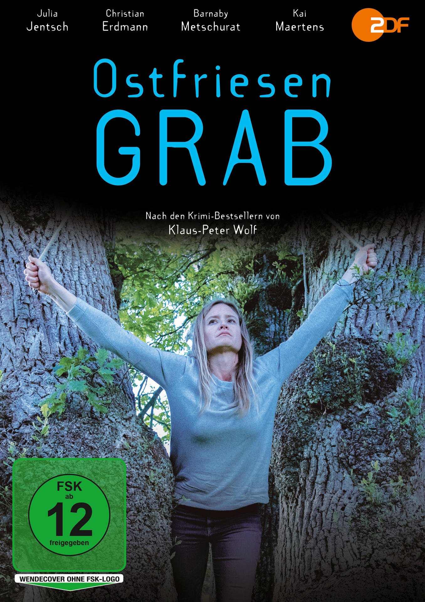 Eine Frau steht zwischen zwei Bäumen mit erhobenen Armen. Der Titel "Ostfriesen Grab" steht über ihr. Eine 12+-Bewertung ist unten.