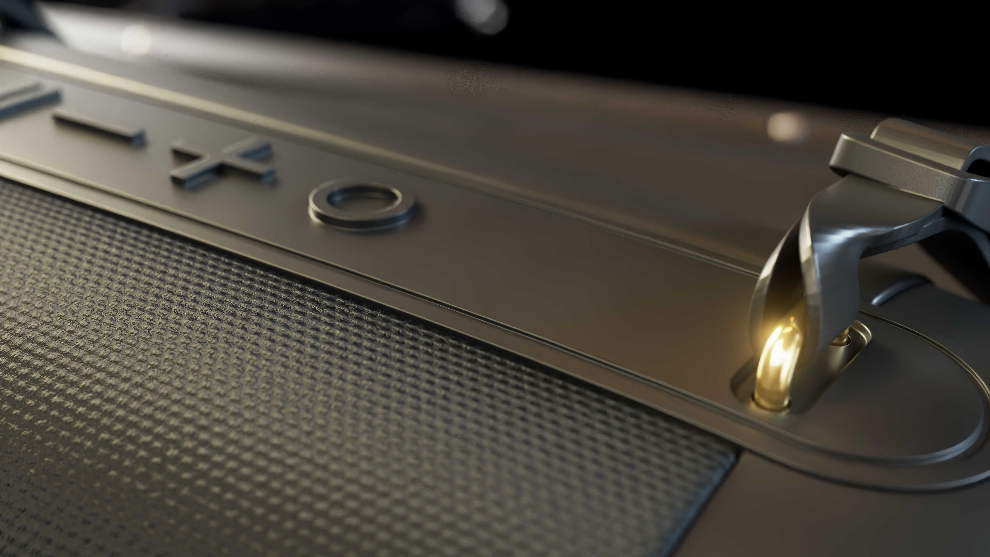 Zbliżenie srebrnej metalowej powierzchni z wytłoczonymi literami 'X' i 'O'. Po prawej uchwyt, ze złotym światłem.