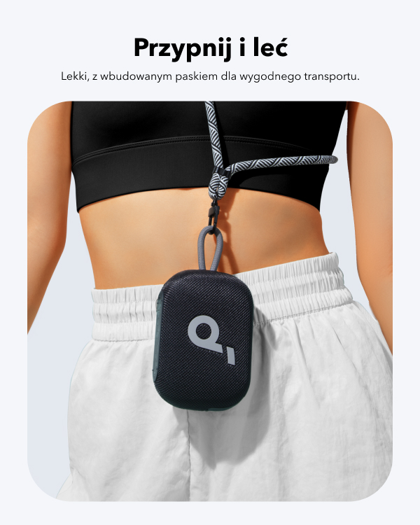 Kobieta w czarnym staniku sportowym i białych spodenkach. Mały czarny głośnik z szarym paskiem wisi na jej szyi.