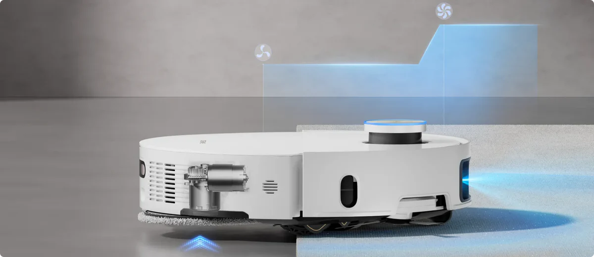 Egy fehér robotporszívó. Szőnyegen van, kék fénnyel. Felül kék grafikai elemek is találhatók.