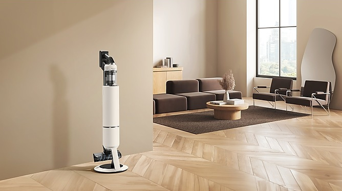 Nowoczesny salon z odkurzaczem, sofą, krzesłami, stolikiem kawowym i dużym oknem z widokiem na miasto.