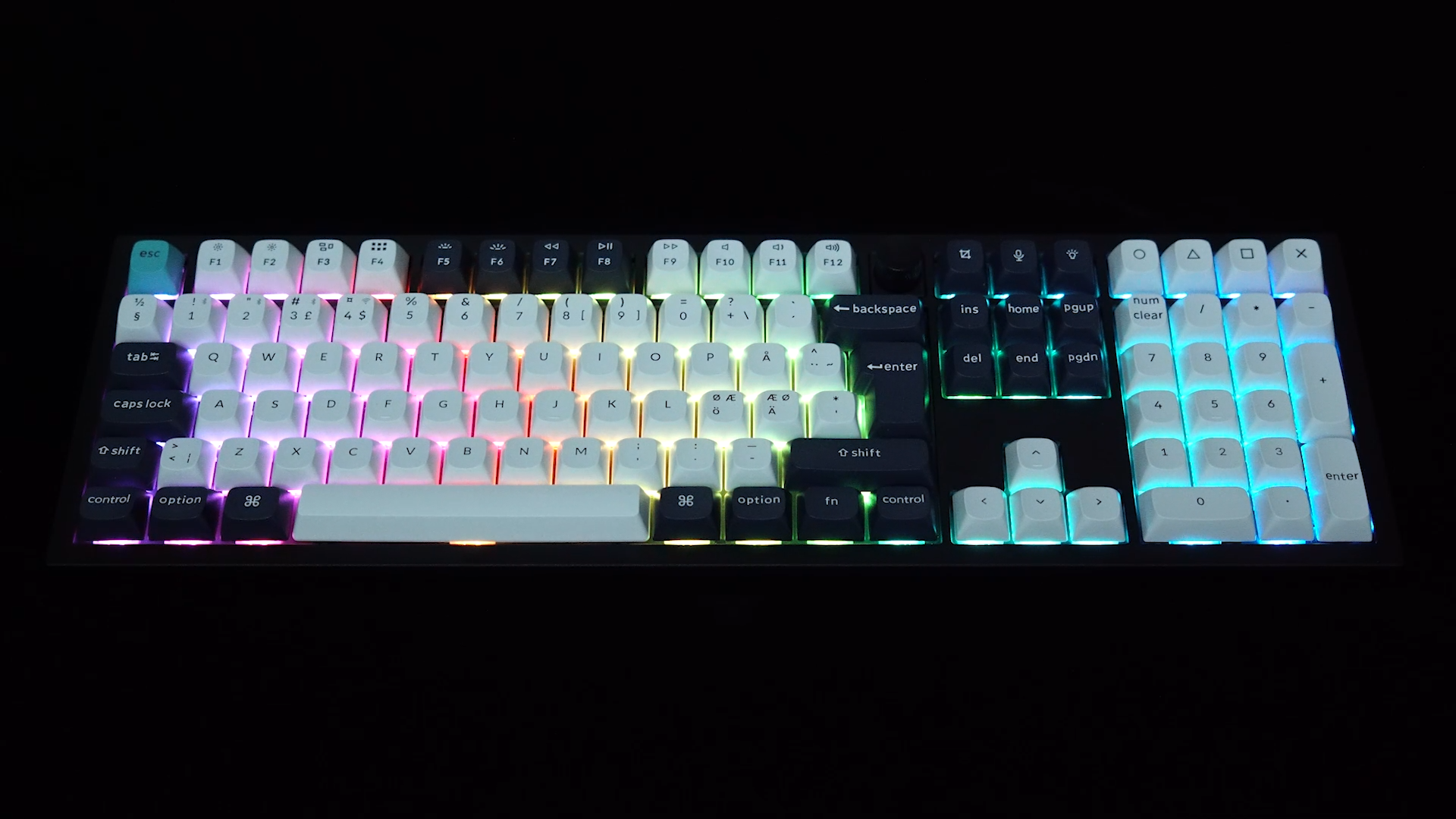 Eine beleuchtete mechanische Tastatur mit weißen Tasten und schwarzem Rahmen. Tasten sind beschriftet.