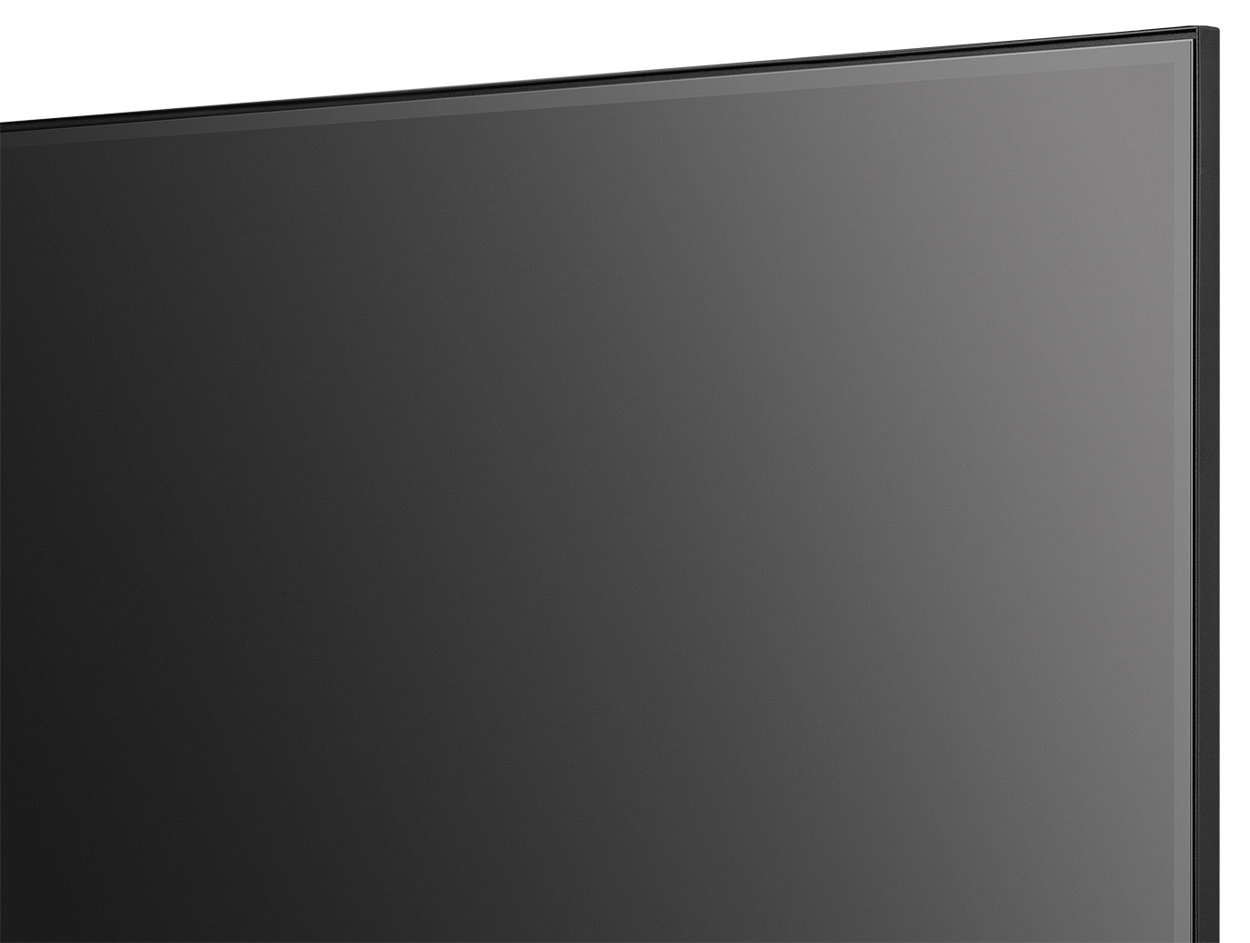 Zbliżenie dużego, ciemnoszarego ekranu z cienką czarną ramką. Ekran odbija światło.