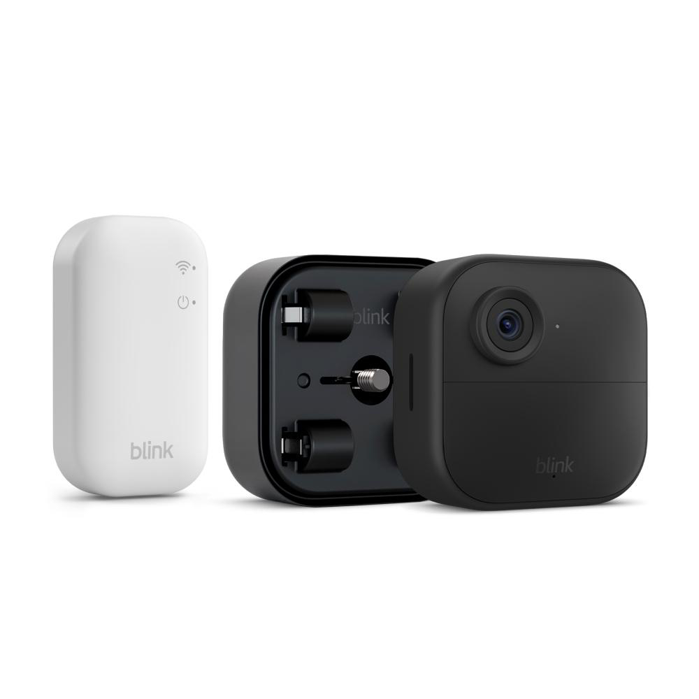 Ein weißes Blink-Sync-Modul, eine schwarze Sicherheitskamera und ein schwarzes Gehäuse mit Zubehör auf weißem Hintergrund.
